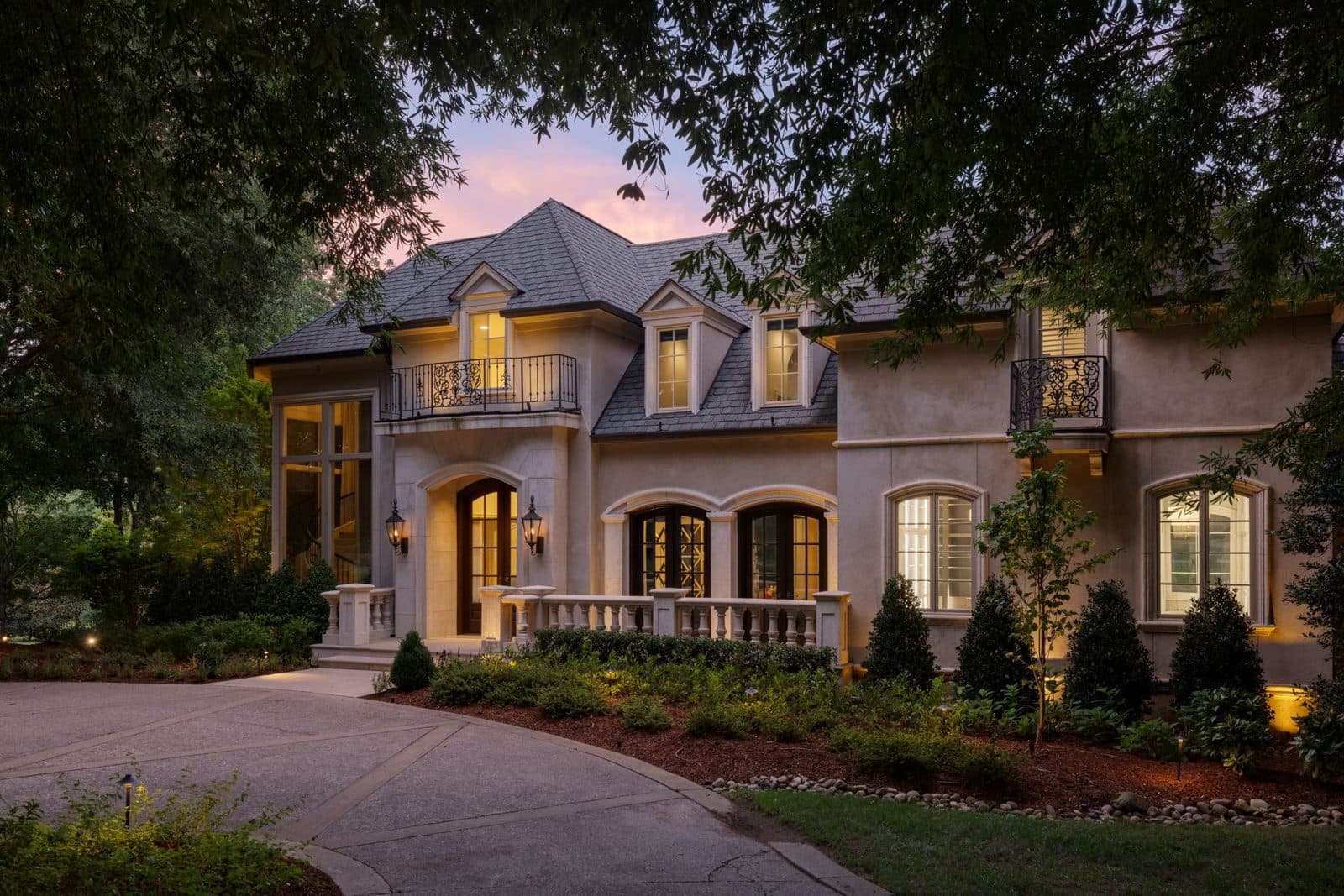Street facing front exterior of the stone and brick estate at dusk at 834 Tyne Valley Ct, one of the Oak Hill homes for sale in Oak Hill Nashville