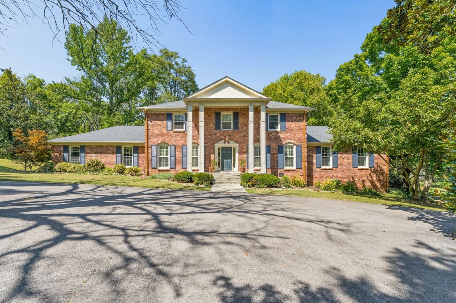 Street facing front exterior of the reclaimed brick colonial at dusk at 806 Willowdale Ct, one of the Oak Hill homes for sale in Oak Hill Nashville